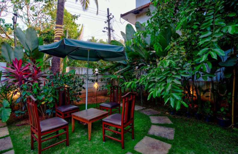 Outdoor garden seating area with umbrella in Morjim villa