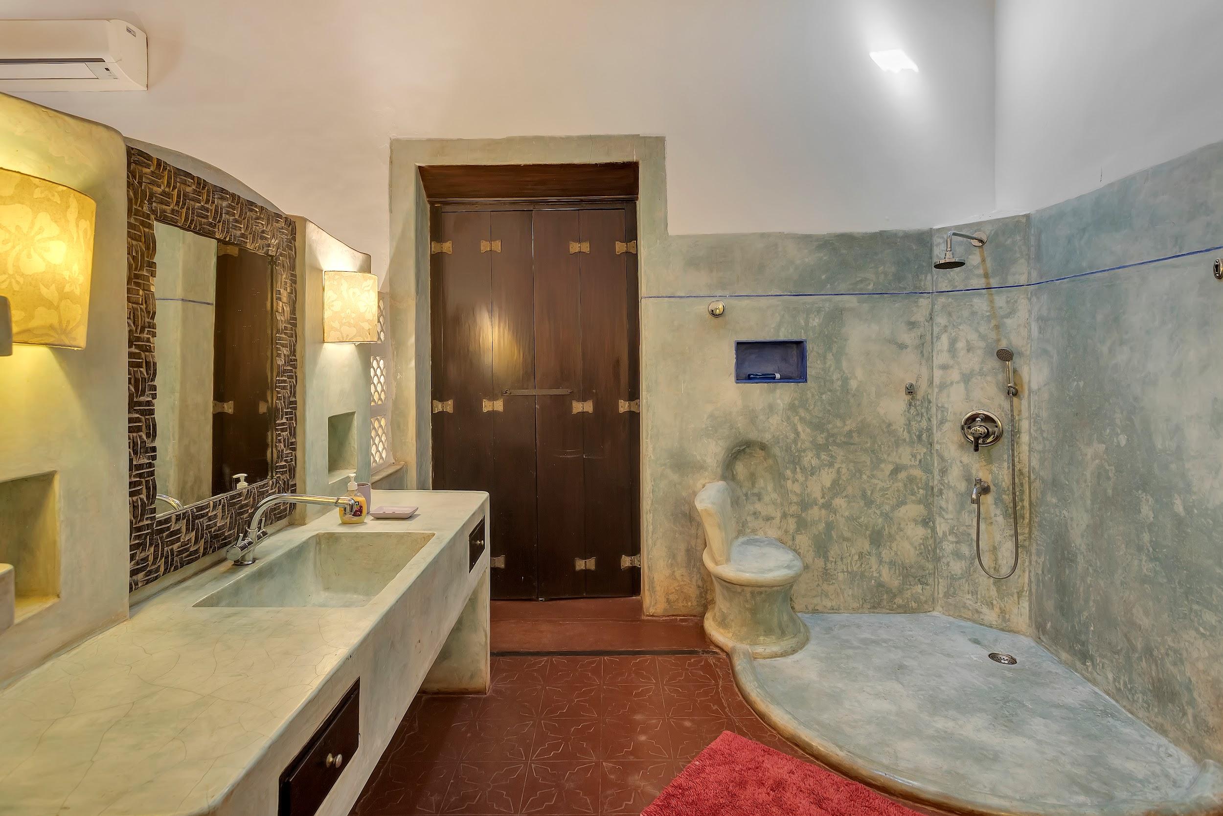 Rustic bathroom with blue textured walls, a stone vanity, and a dark wooden door