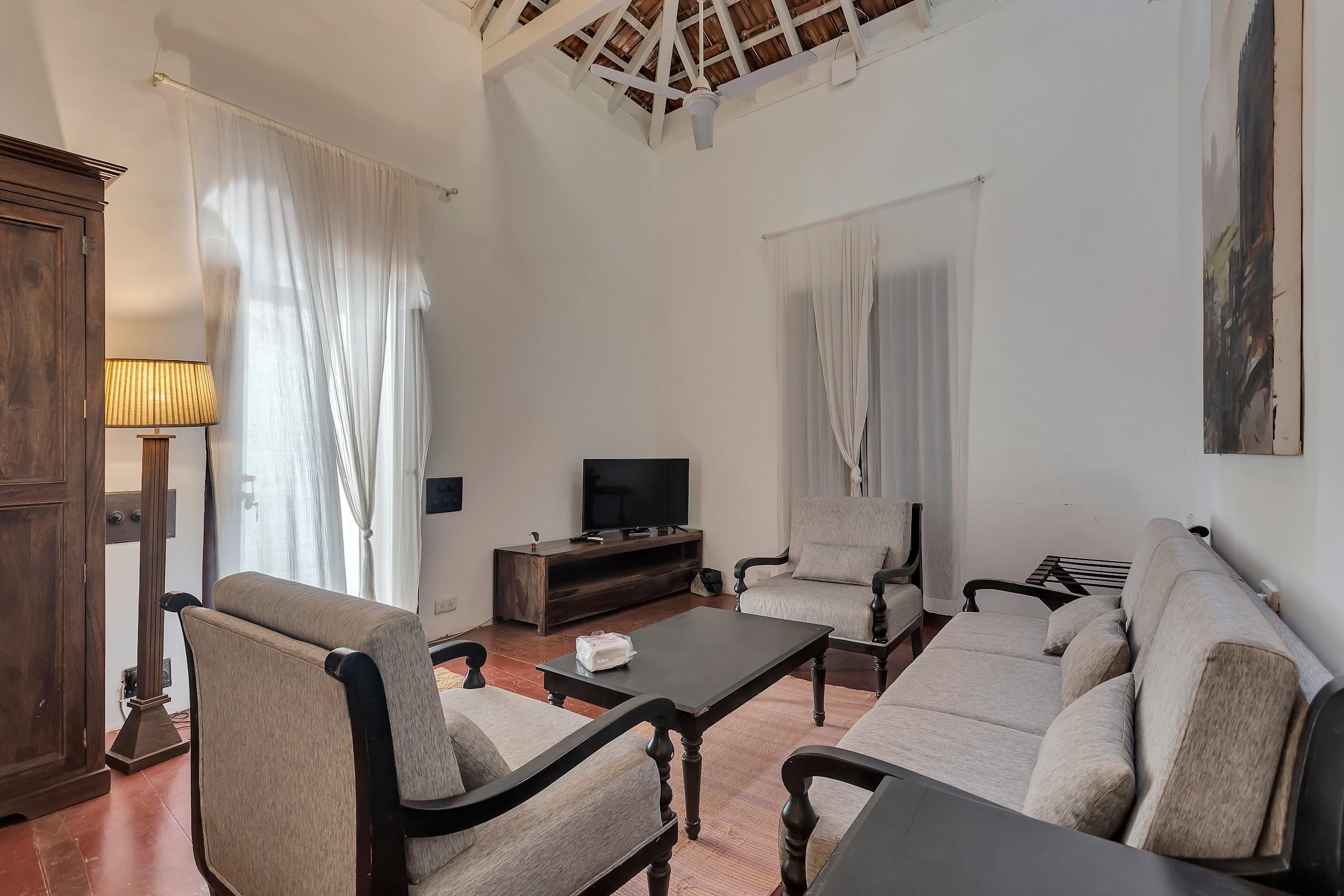 Living room with light grey modern sofas, a dark coffee table, and an exposed wooden beam ceiling