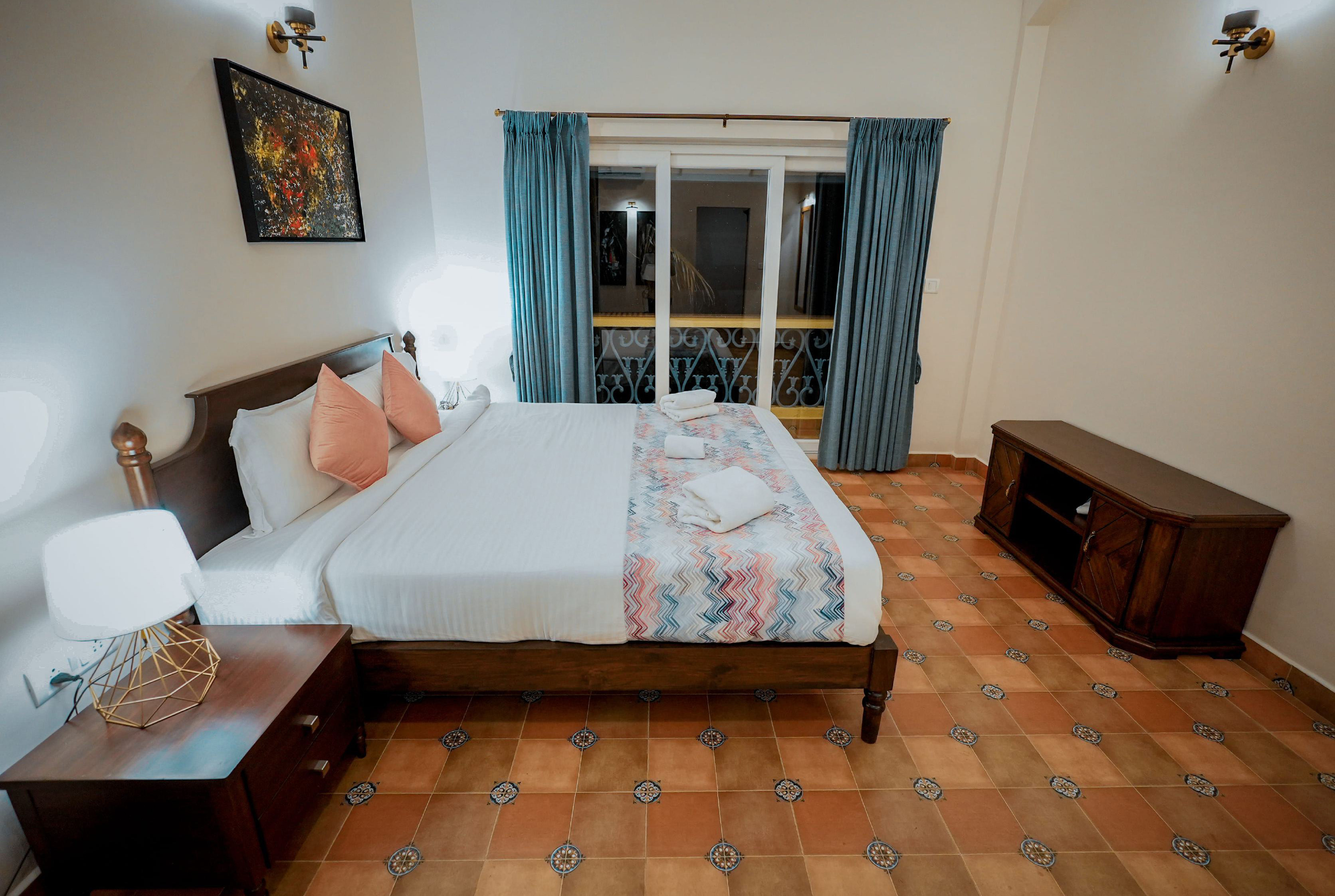 Spacious villa bedroom with king-size bed and balcony view