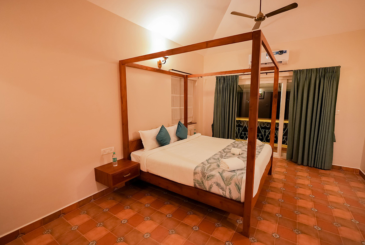Spacious bedroom featuring four-poster bed and green curtains