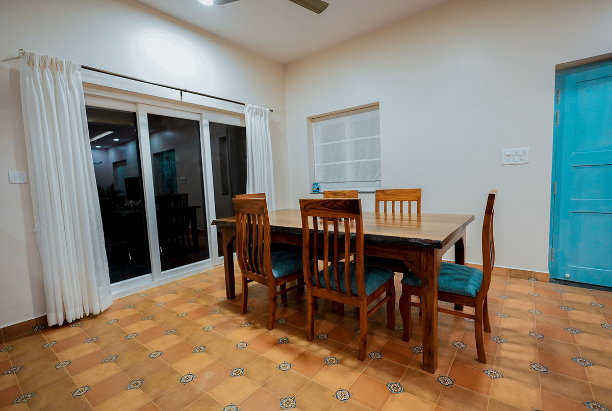 Dining room with wooden chairs and sliding glass doors.