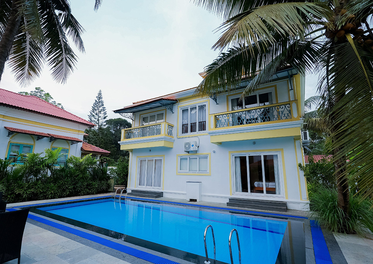 Modern villa exterior with swimming pool and palm trees.