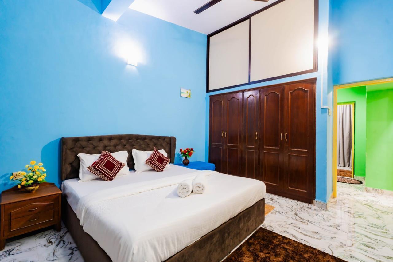 Blue bedroom, large bed, brown wardrobes, and doorway to green room.