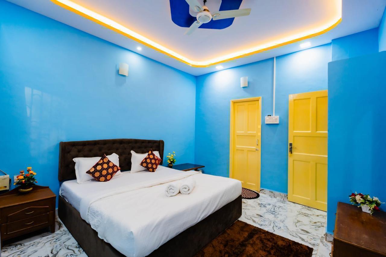 Blue bedroom with large bed, brown headboard, white bedding, and yellow doors.