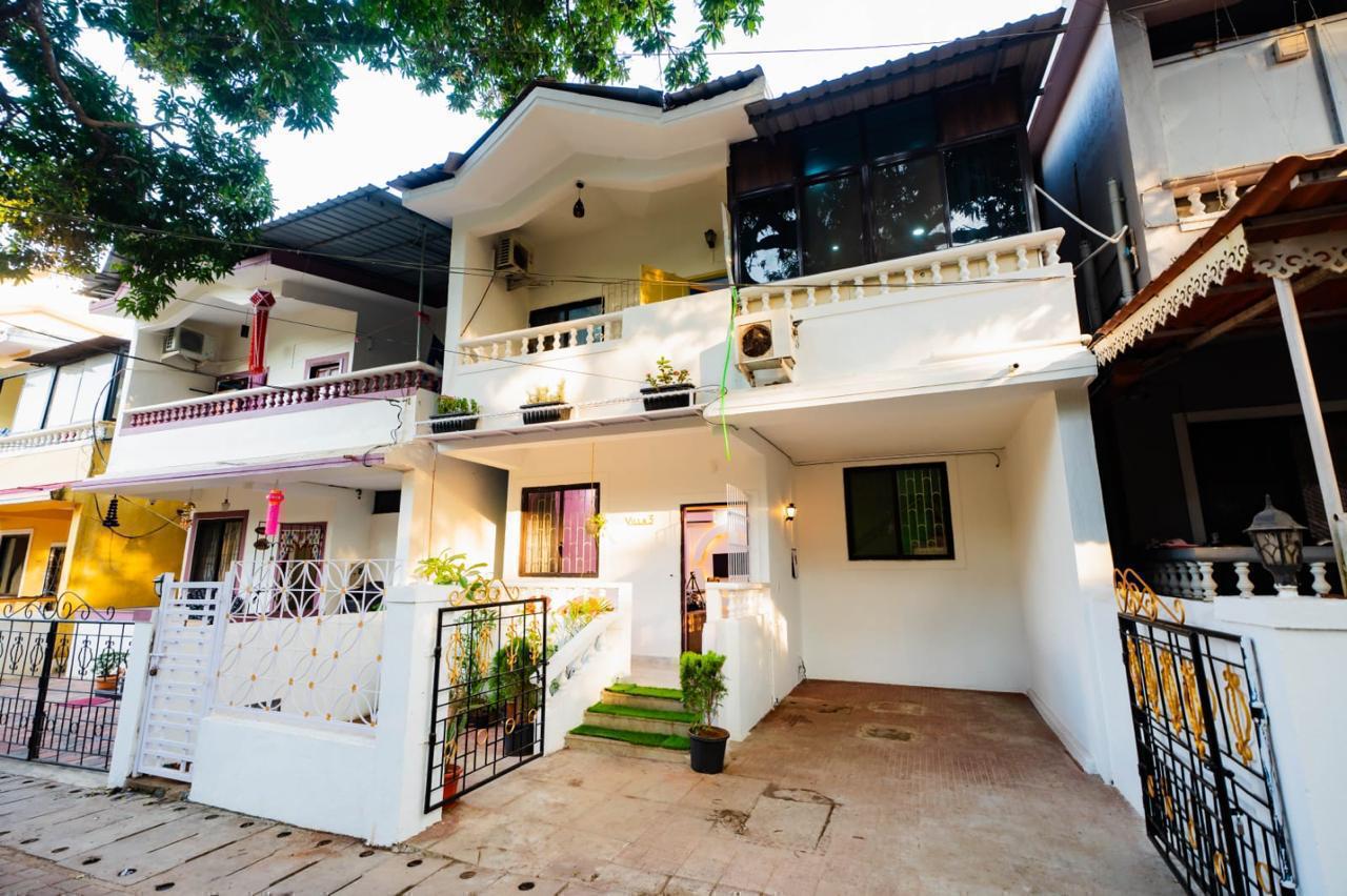 Exterior of a white multi-story house with a front gate and driveway