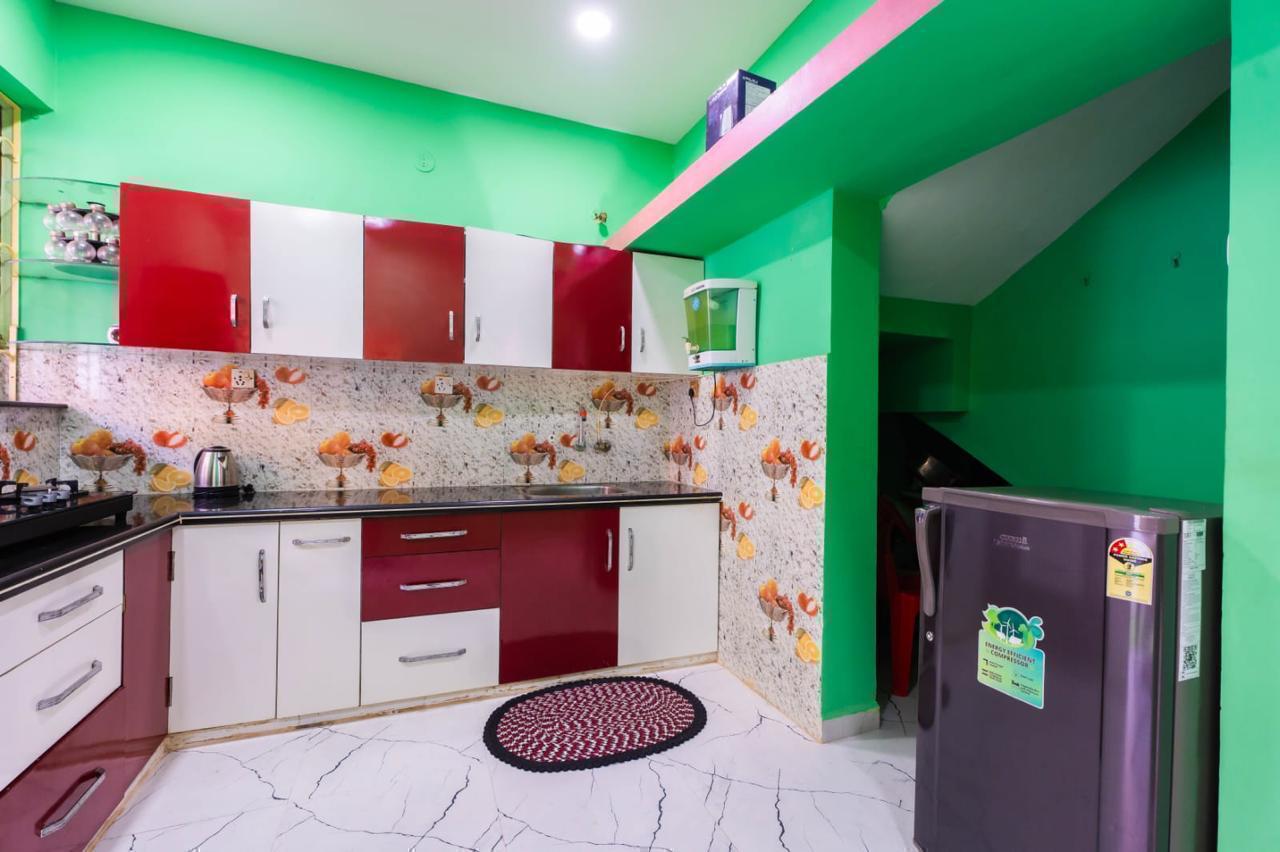 Kitchen with red/white cabinets, fruit tiles, window, refrigerator, and mint green walls.