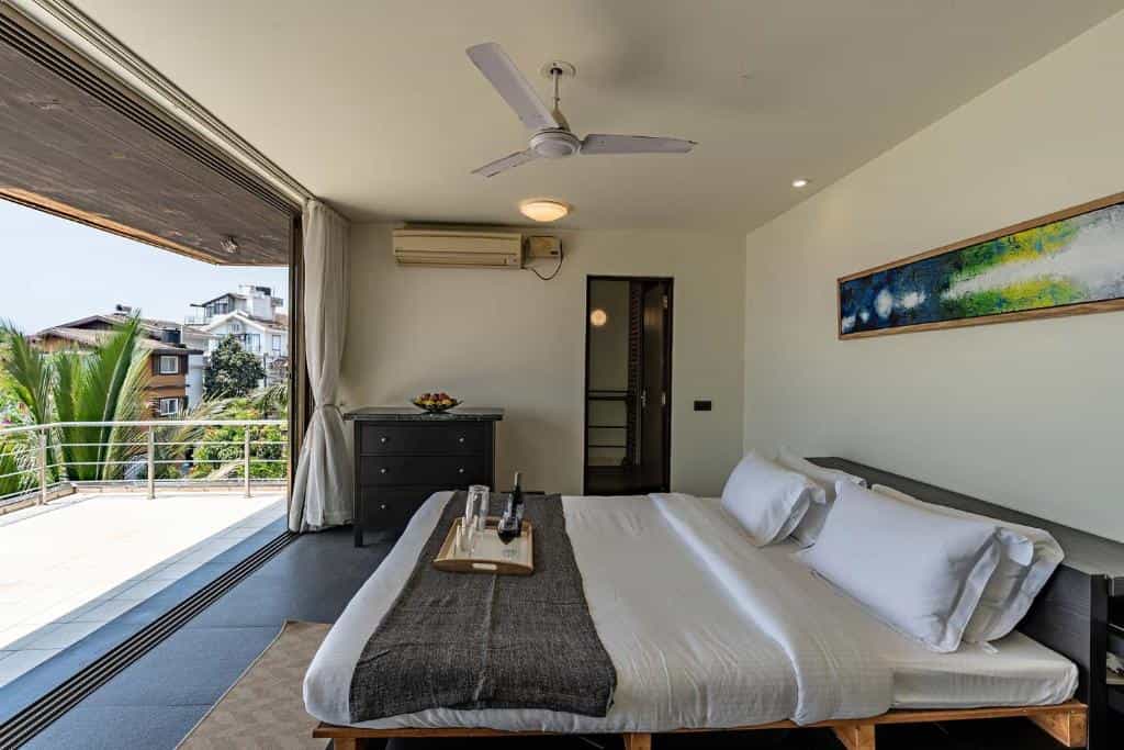 Villa bedroom with king bed and balcony view