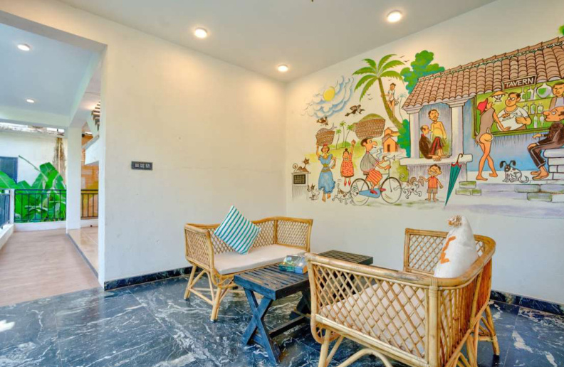 Lounge seating area with colorful Goa village mural wall art