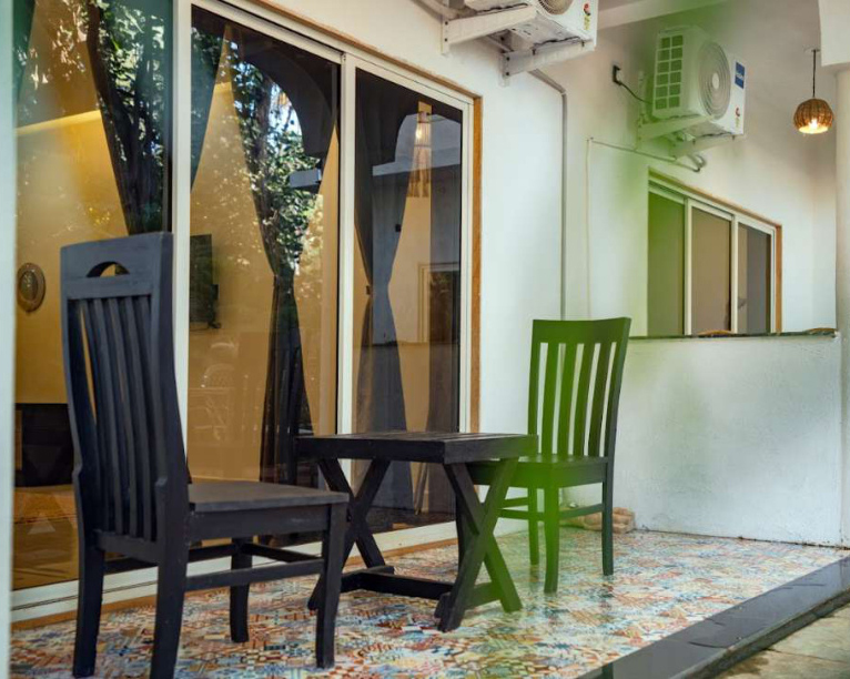 Private villa balcony seating area with chairs and small table outside the room