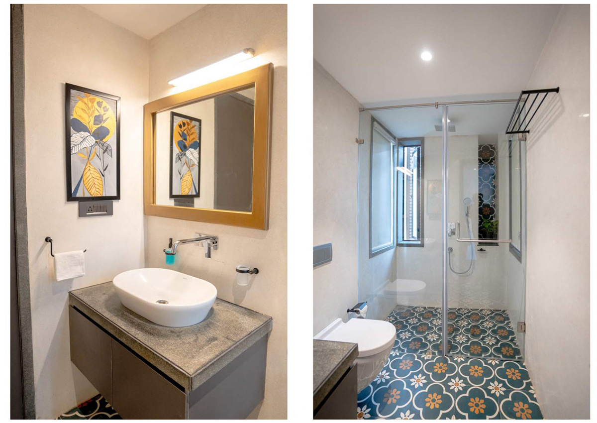 Stylish bathroom featuring patterned floor tiles, concrete vanity, and walk-in glass shower