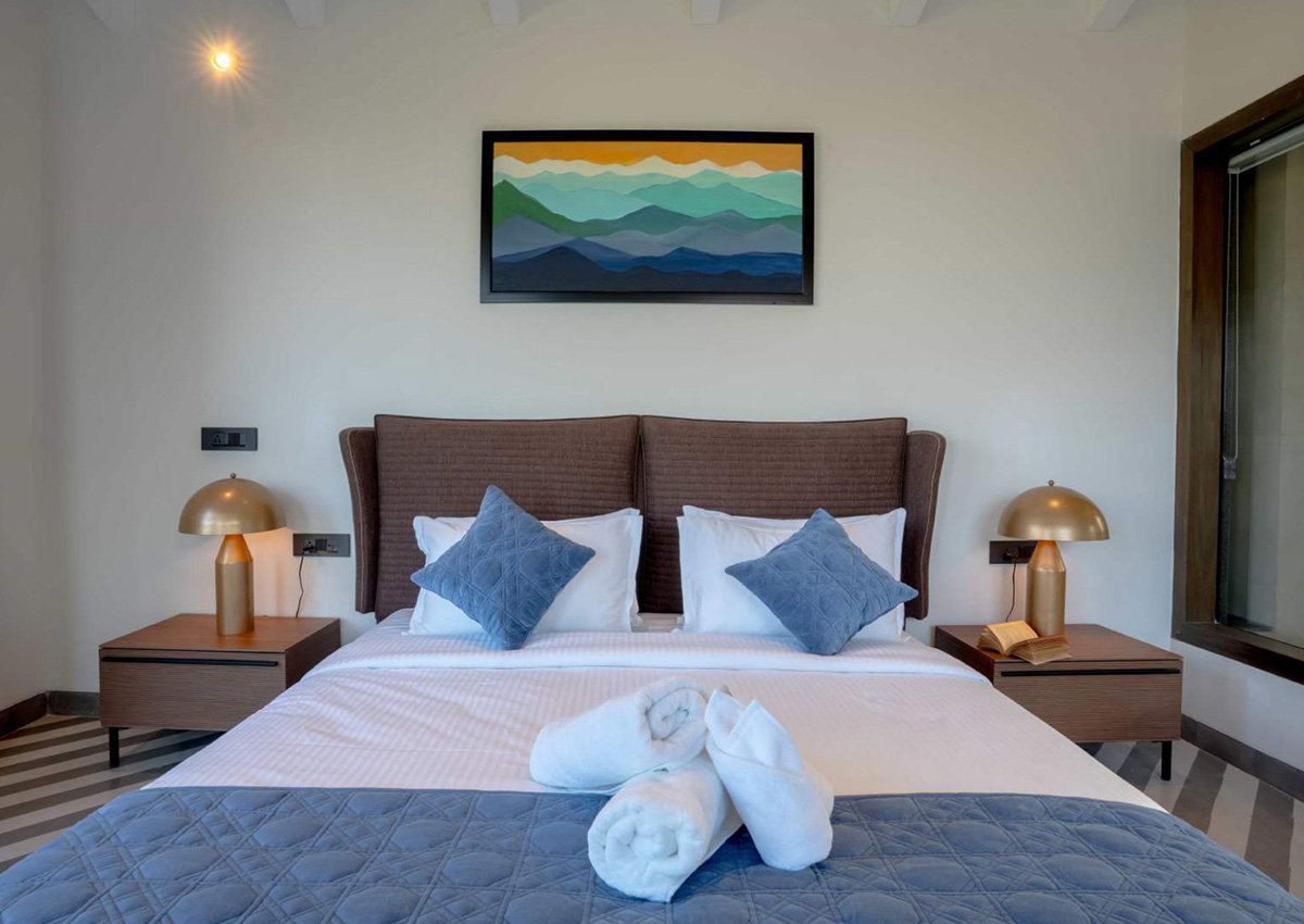 Straight-on view of blue-accent suite with patterned floor and large framed artwork