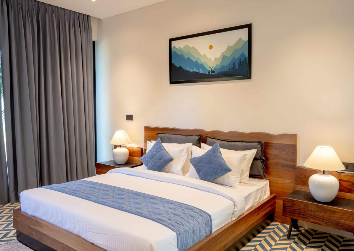 Window side of bedroom with long grey curtains and garden views