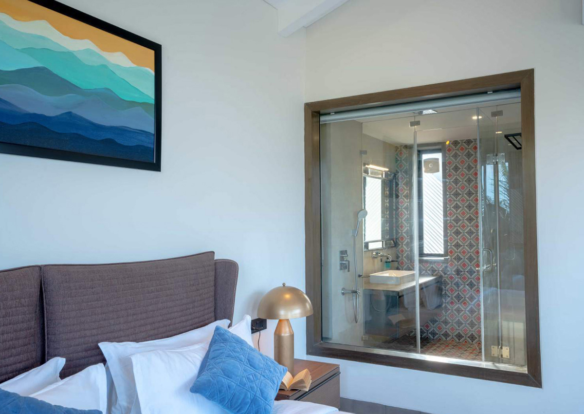 Modern bedroom with glass-panel view into a stylish bathroom