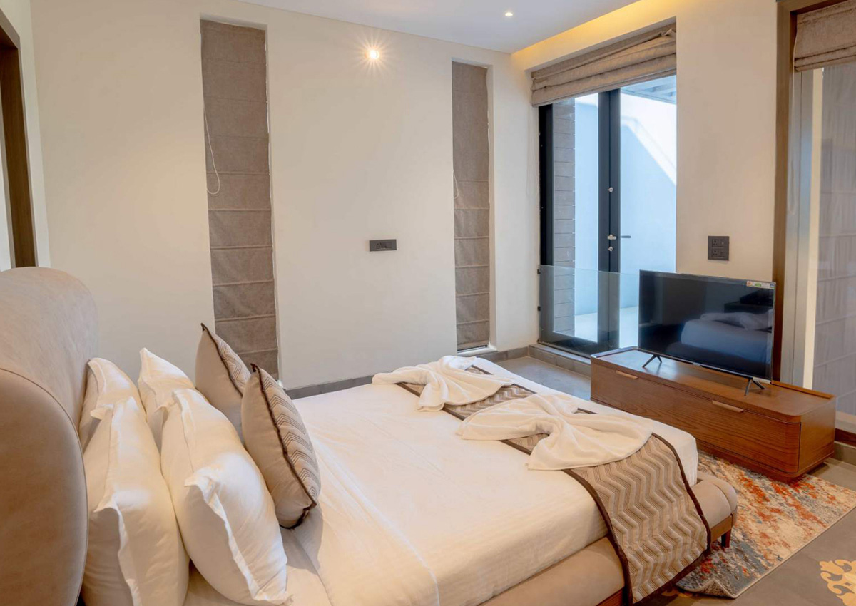 Bedroom with TV corner and sliding door leading to balcony