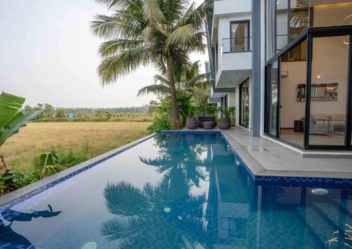 Infinity-edge pool beside palm trees with open landscape views