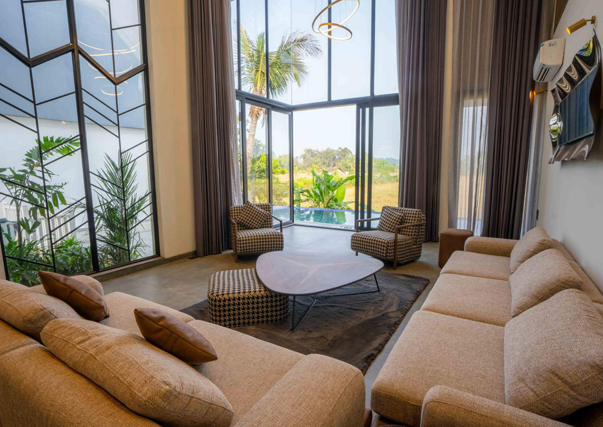 Spacious living room with double-height glass windows and cozy seating