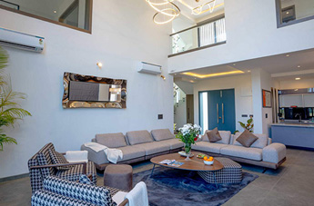 Wide-angle view villa of living room with neutral furnishings and natural light