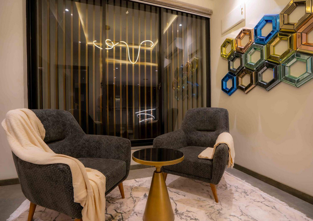 Cozy lounge corner with two armchairs, soft lighting, and decorative wall art