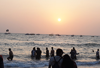 People enjoying the beach at sunset in Goa