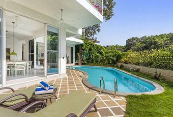Curved swimming pool beside a modern villa.